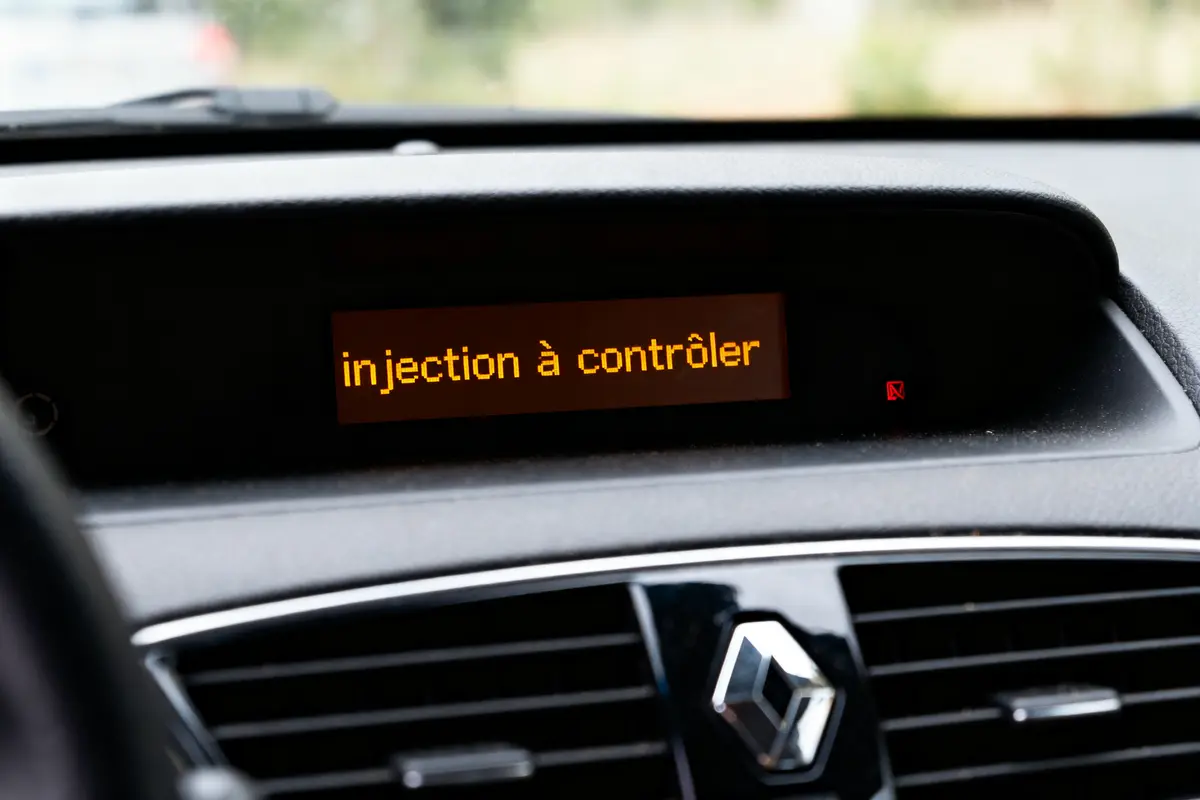 Tableau de bord de voiture avec message "injection à contrôler" affiché.