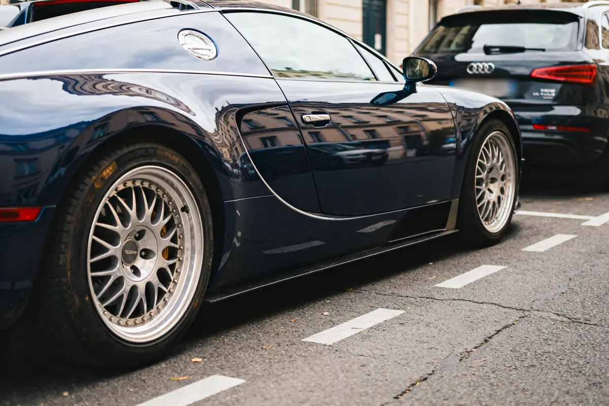 Voiture de luxe EB 16.4 Veyron garée dans la rue avec jantes chromées.
