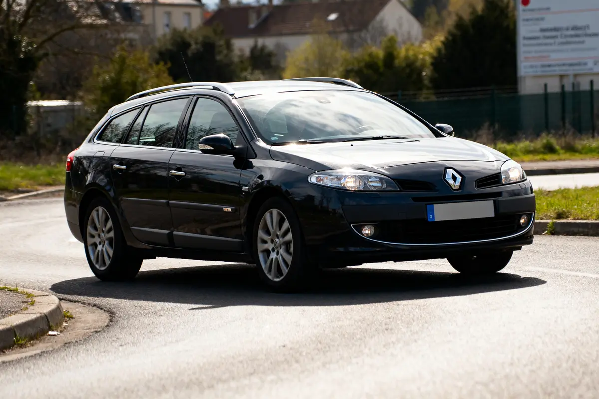 Voiture noire Renault Laguna cars roulant sur une route ensoleillée