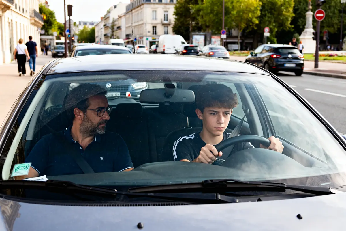 Adolescent conduit avec un adulte supervision en conduite accompagnée à 15 ans en ville
