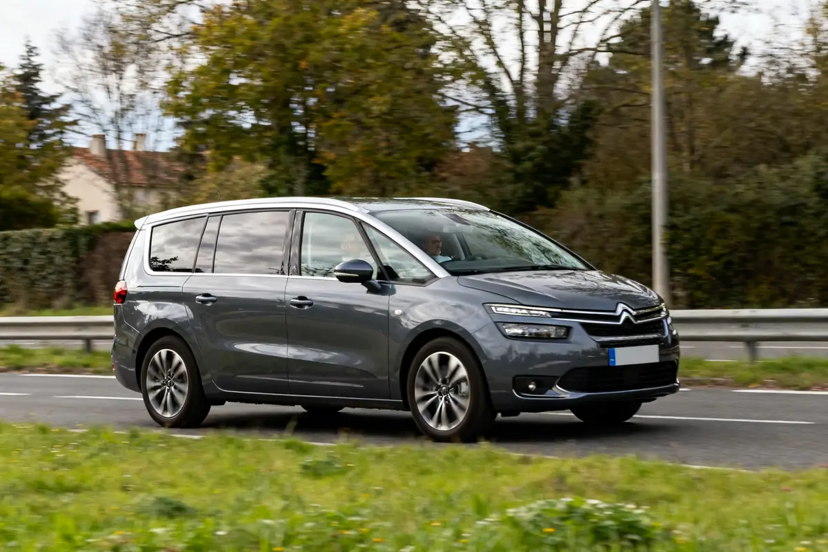 Monospace gris sur route, typique voiture 7 places pour famille ou voyage en groupe
