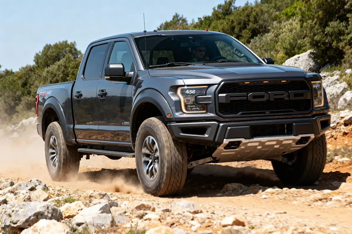 Pickup Ford Raptor 4 door gris sur chemin rocailleux en pleine nature