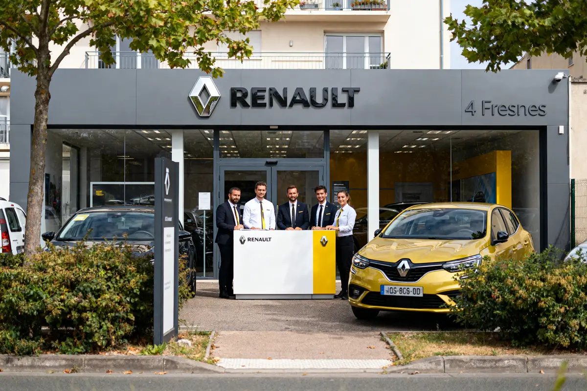Personnel devant concession Renault Fresnes avec voiture jaune et logo bien visible sur le bâtiment