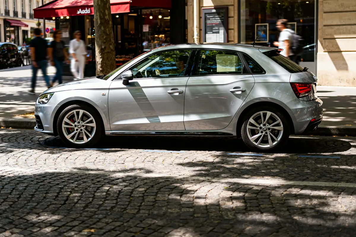 Voiture automatic Audi A1 grise garée en ville sur pavés ombragés