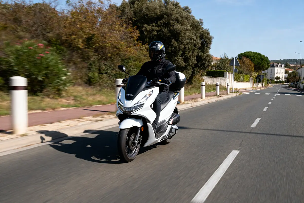 Conducteur sur Honda PCX 125 en mouvement, illustrant la vitesse maximale du modèle